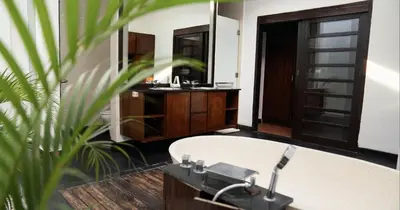 a bathroom with a tub and a sink and a mirror at Villa Nata Umalas in Seminyak