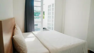 a white bed in a room with a large window at Apartment Nata Umalas in Seminyak