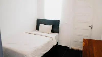 a small bedroom with two beds and a door at Apartment Nata Umalas in Seminyak