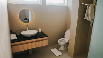 a bathroom with a sink and a toilet and a mirror at Apartment Nata Umalas in Seminyak