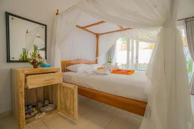 a bedroom with a bed with a canopy at sari uma in Seminyak