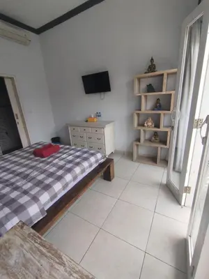 a bedroom with a bed and a tv on the wall at sari uma in Seminyak