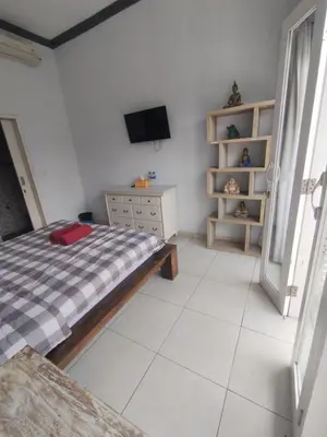 a bedroom with a bed and a tv in it at sari uma in Seminyak