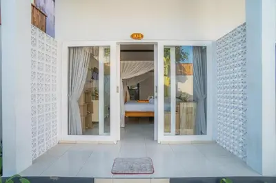 a white room with a bedroom with a bed at sari uma in Seminyak
