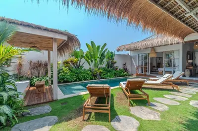 a villa with a swimming pool and chairs at NEW 3BR Fleur De Vie Tranquility Villa in Seminyak in Seminyak