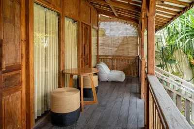 a porch of a house with a table and a stool at Tuluscoliving Villa Kuta 4, 2 Bedroom & 2 Bathroom in Ngurah Rai International Airport