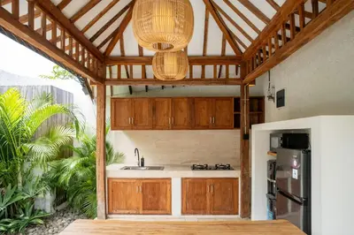 a kitchen with wooden cabinets and a sink at Tuluscoliving Villa Kuta 4, 2 Bedroom & 2 Bathroom in Ngurah Rai International Airport