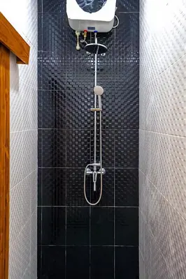 a black tiled shower with a white sink in a bathroom at Modern 2BR Villa in Seminyak Center - Private Pool in Seminyak