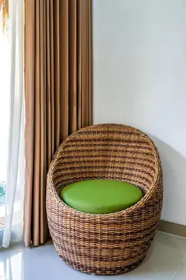 a wicker chair sitting in front of a window at Modern 2BR Villa in Seminyak Center - Private Pool in Seminyak