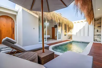 a villa with a swimming pool and an umbrella at Modern 2BR Villa in Seminyak Center - Private Pool in Seminyak
