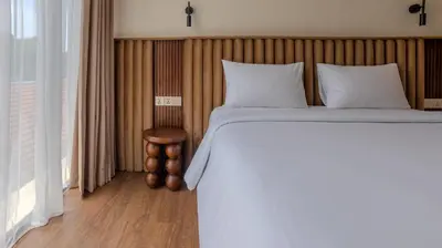a bedroom with a large bed and a window at Suom Apartments and Villas Canggu in Canggu