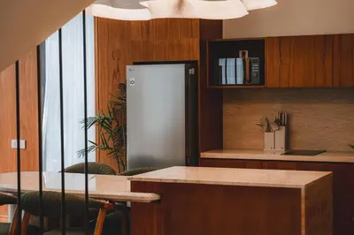 a kitchen with a stainless steel refrigerator and a table at Suom Apartments and Villas Canggu in Canggu