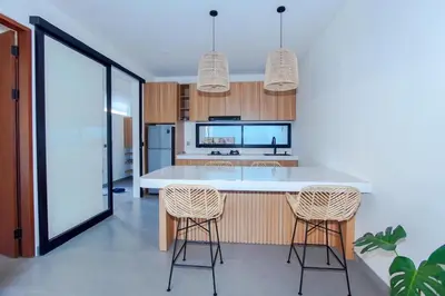 a kitchen with a white counter and two bar stools at Rama Villa Umalas in Kerobokan