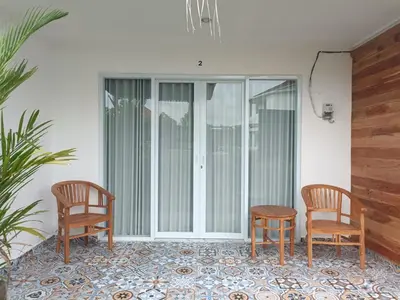two chairs and a table on a patio at Dongsoul Guest House in Legian