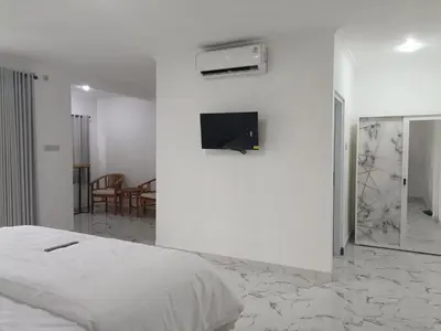 a bedroom with a bed and a tv on a wall at Dongsoul Guest House in Legian