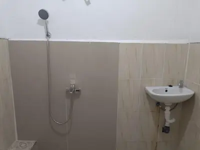 a bathroom with a shower and a sink at Dongsoul Guest House in Legian