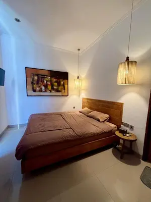 a bedroom with a bed and two pendant lights at Uma Mari Villa Seminyak in Seminyak