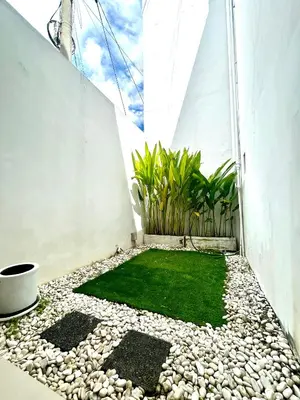 a small garden with rocks and grass on a patio at Uma Mari Villa Seminyak in Seminyak
