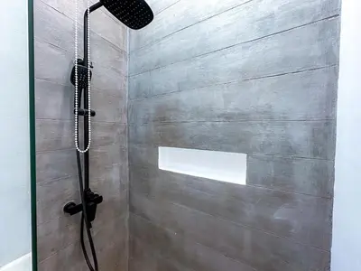 a shower with a glass door in a bathroom at Desa Hut - 2BR Tropical Ricefield Villa near Seminyak in Kerobokan