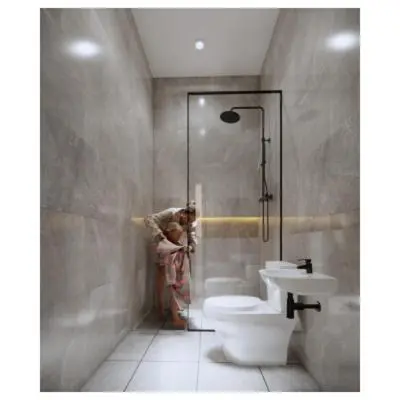 a woman in a bathroom with a toilet and a shower at Moonlit Haven in Jimbaran