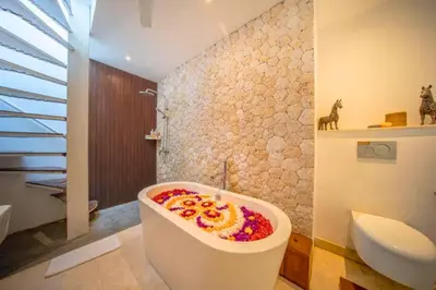 a bathroom with a bath tub with flowers on it at Daiva Comfortable 1 BR Private Pool Villa in Jimbaran