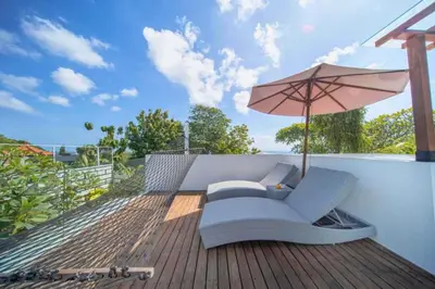 a patio with an umbrella and a chair and an umbrella at Daiva Comfortable 1 BR Private Pool Villa in Jimbaran