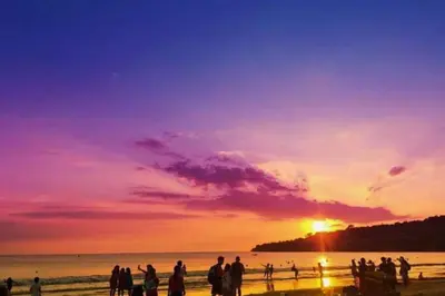a group of people standing on the beach at sunset at Daiva Comfortable 1 BR Private Pool Villa in Jimbaran