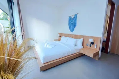 a bedroom with a bed with white sheets and pillows at Rama Villa Umalas in Kerobokan