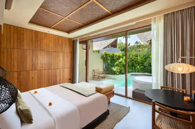 a bedroom with a bed and a table and a tub at Alena Cozy 1 BR Private Pool Villa With Lagoon Access in Seminyak