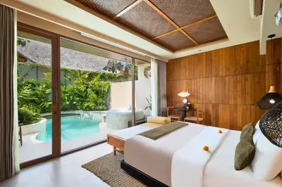 a bedroom with a bed and a swimming pool at Alena Cozy 1 BR Private Pool Villa With Lagoon Access in Seminyak