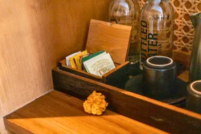 a wooden shelf with a box of books and a bottle at Alora Comfortable 1 BR Smart Pool Villa With Jacuzzi in Seminyak