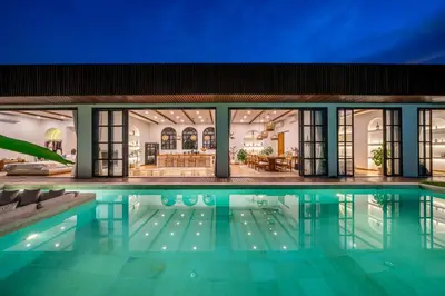 a house with a swimming pool at night at Palm Sugar 2-Chic 3BR Villa in Jimbaran with Pool&Garden in Jimbaran