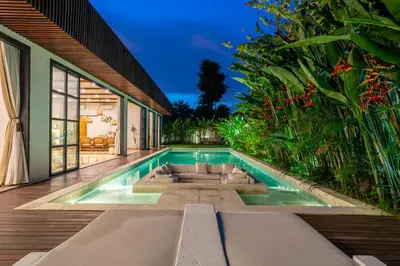 an infinity pool in the backyard of a house at Palm Sugar 2-Chic 3BR Villa in Jimbaran with Pool&Garden in Jimbaran