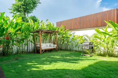 a garden with a chair and a gazebo at Palm Sugar 2-Chic 3BR Villa in Jimbaran with Pool&Garden in Jimbaran