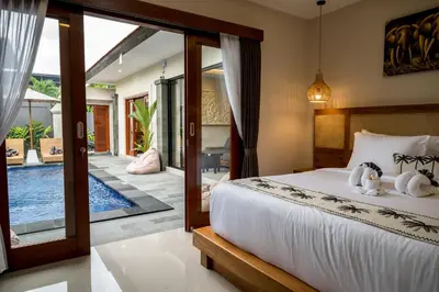 a bedroom with a bed and a patio with a pool at Villa Inges 3 Seminyak in Seminyak