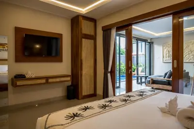 a bedroom with a bed with a television and a living room at Villa Inges 3 Seminyak in Seminyak
