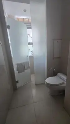 a white bathroom with a toilet and a shower at Villa Don Bose 8 in Jimbaran