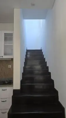 a black staircase in a room with a kitchen at Villa Don Bose 8 in Jimbaran