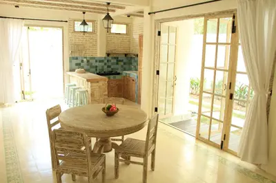 a kitchen and dining room with a table and chairs at M-Apartment in Badung