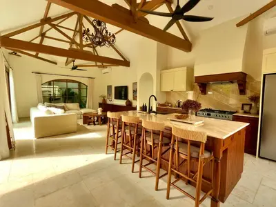 a kitchen with a large island with bar stools at Casa Mañana Villa Legian, Kuta in Legian