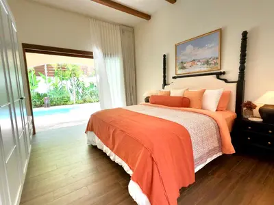 a bedroom with a bed with an orange blanket at Casa Mañana Villa Legian, Kuta in Legian
