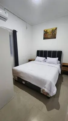 a bedroom with a large bed with white sheets at House of Tomolowicz in Jimbaran