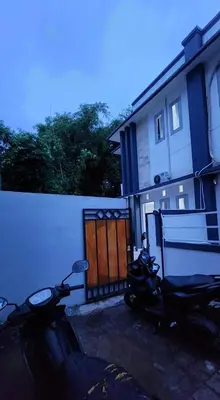 two motorcycles parked next to a building with a fence at House of Tomolowicz in Jimbaran