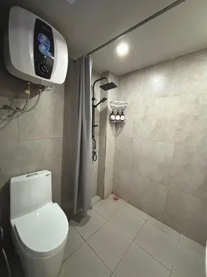 a bathroom with a toilet and a shower at Olive Athena Guesthouse in Seminyak