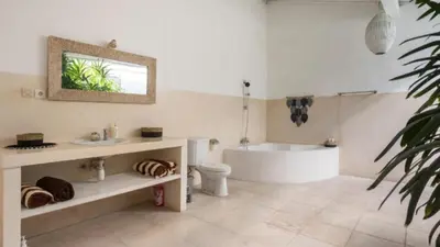 a bathroom with a tub and a toilet and a sink at Villa VITA in Seminyak