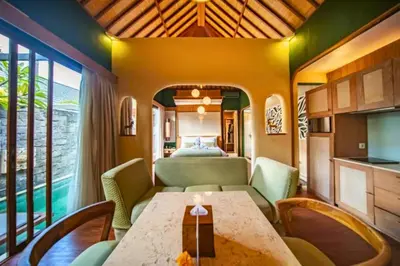 a living room with a table and a bedroom at Edna Royal 1 BR Private Pool Villa With Jacuzzi in Legian