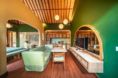 a green living room with a couch and a tv at Edna Royal 1 BR Private Pool Villa With Jacuzzi in Legian