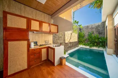 a kitchen and a swimming pool in a house at Azula Cozy Royal 2 BR Private Pool Villa With Jacuzzi in Legian