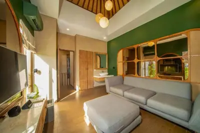 a living room with a couch and a flat screen tv at Azula Cozy Royal 2 BR Private Pool Villa With Jacuzzi in Legian