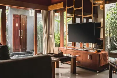 a living room with a tv and a couch at Bahira Lovely 1 BR Grand Pool Villa With Bathtub in Legian